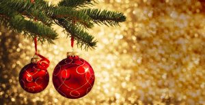 Christmas bauble hanging on pine tree with golden illuminated background